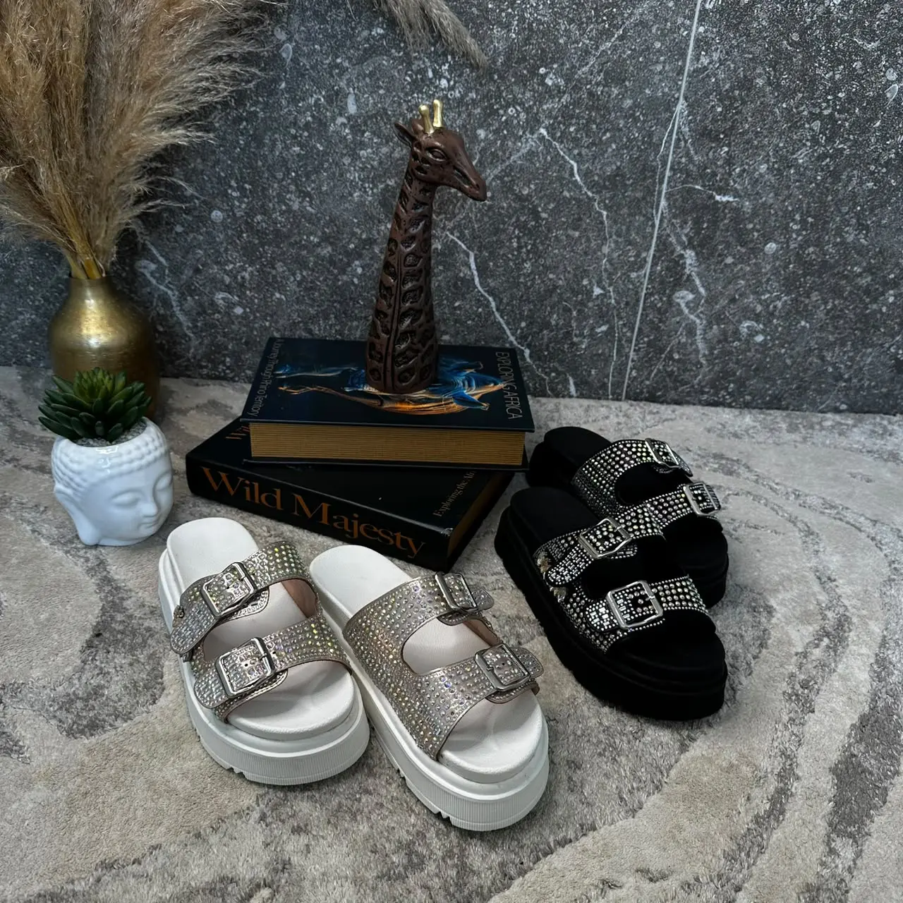 Sandalias de plataforma con doble correa de pedrería brillante en colores blanco y negro, con suela gruesa y detalles de hebillas decorativas.