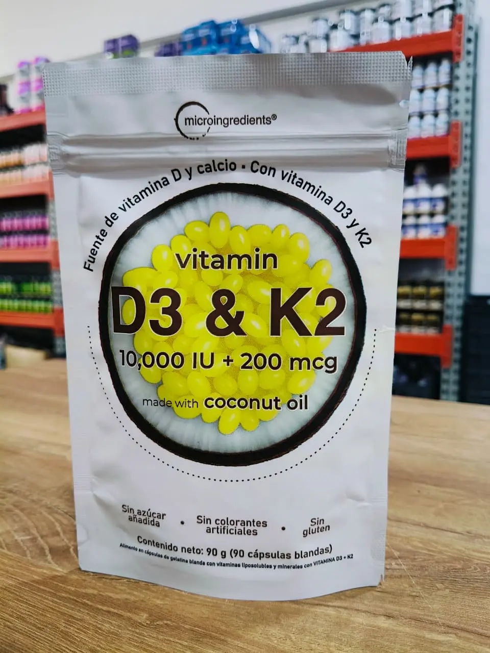 Bolsa blanca de vitamina D3 y K2 de Micro Ingredients con cápsulas amarillas sobre fondo de coco y 90 g de contenido neto.