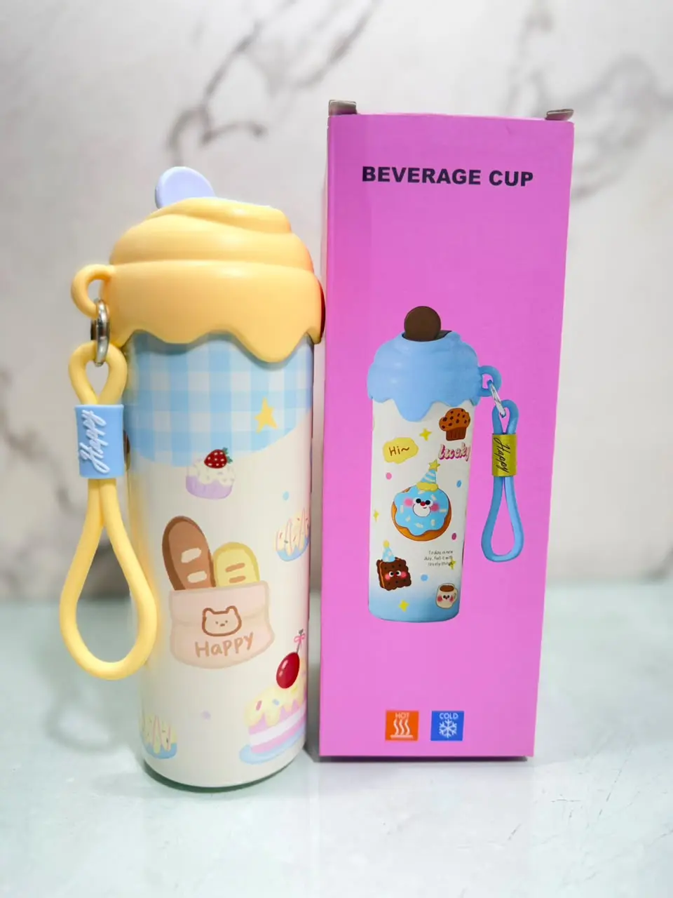 Termo kawaii 600ml color amarillo y celeste con diseño de postres, tapa en relieve, pitillo y caja de empaque rosa.