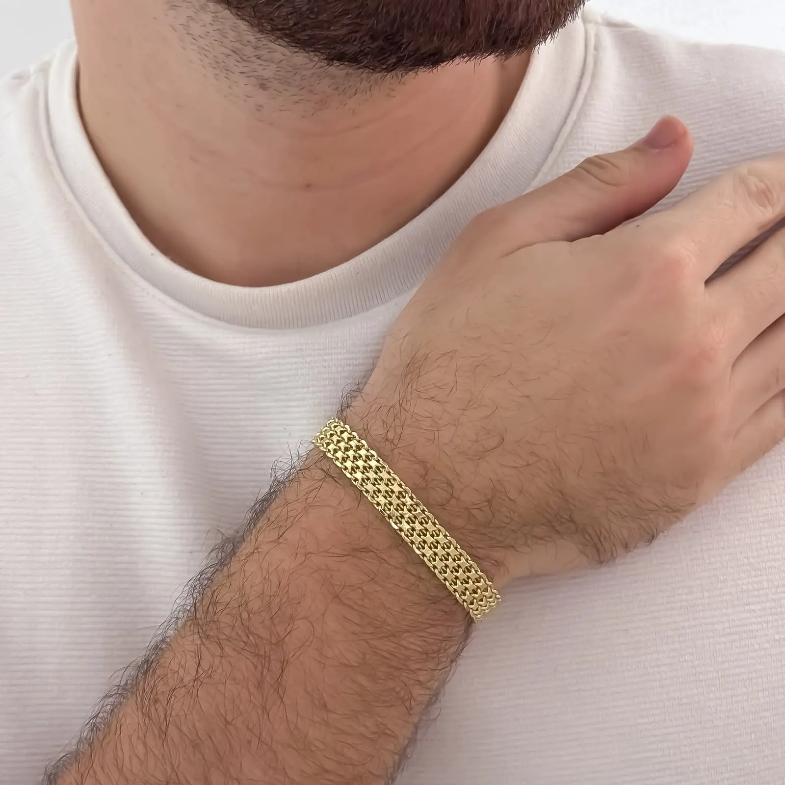 Pulsera de tejido chino grueso en oro laminado de 18k para hombre, con textura de malla dorada sobre la muñeca.