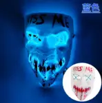 Máscara LED estilo The Purge con texto KISS ME, luces azules en ojos y boca, y variante con detalles rojos.