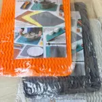 Tapete térmico de silicona naranja con textura ondulada antideslizante, apilado sobre otros protectores grises y blancos en bolsa transparente.