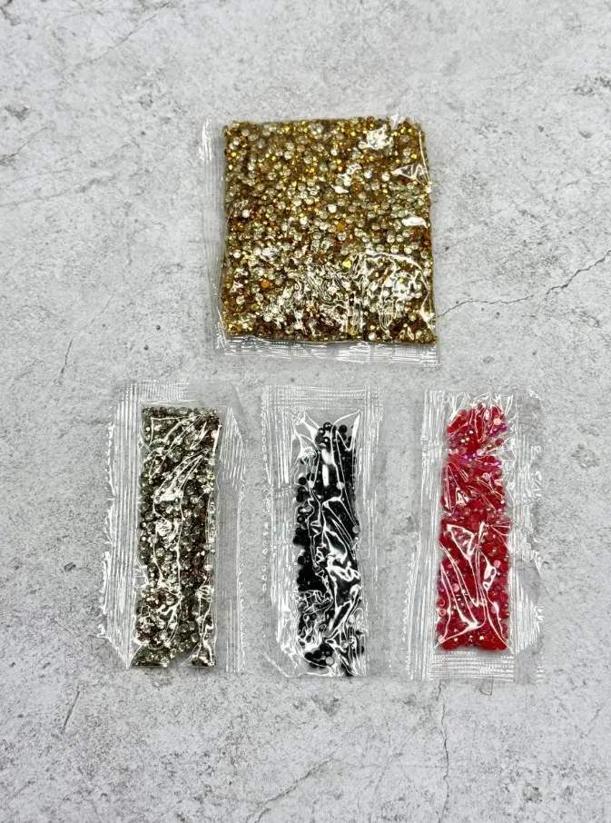Niño colocando piedras brillantes de colores sobre la alcancía usando el aplicador