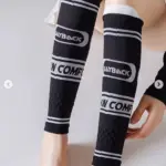 Pantorrilleras de compresión negras con franjas y texto blanco "PLAYBACK" e "IN COMFORT", de tejido elástico para entrenamiento deportivo.