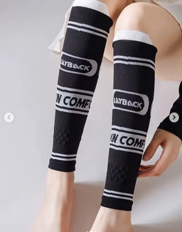Pantorrilleras de compresión negras con franjas y texto blanco "PLAYBACK" e "IN COMFORT", de tejido elástico para entrenamiento deportivo.