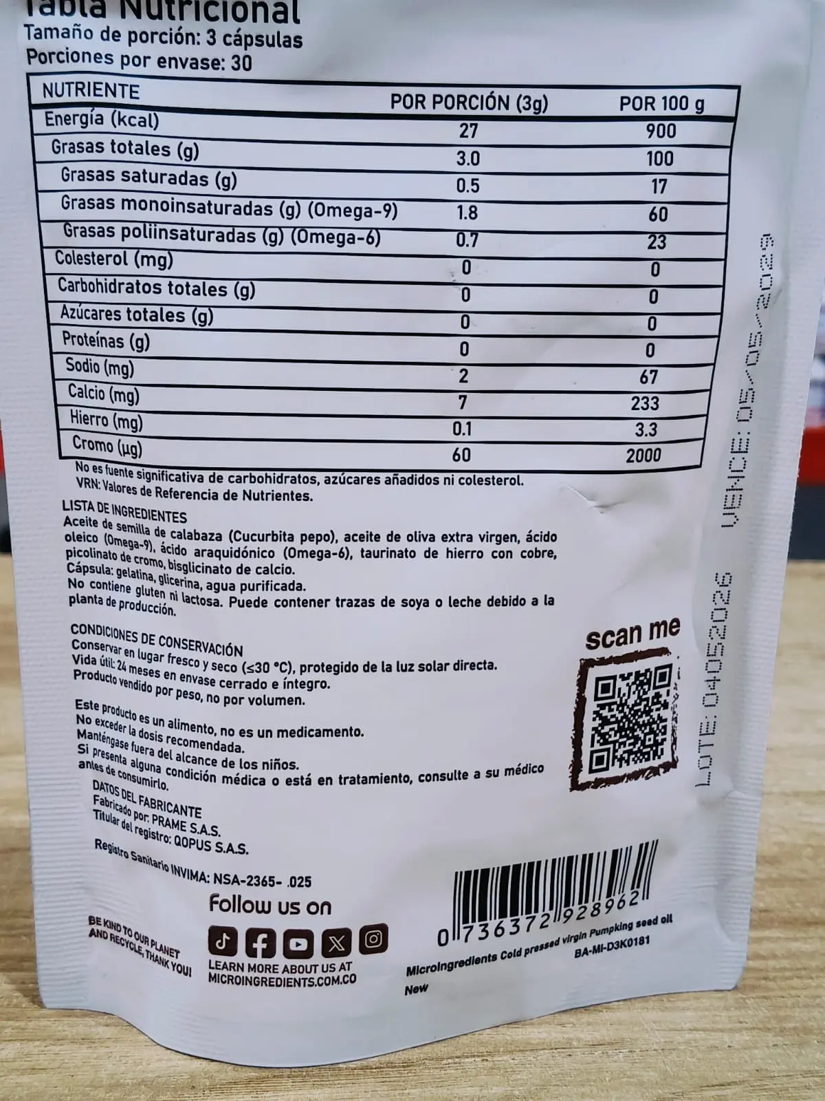 Empaque blanco de cápsulas con tabla nutricional en español, ingredientes visibles y código QR impreso.