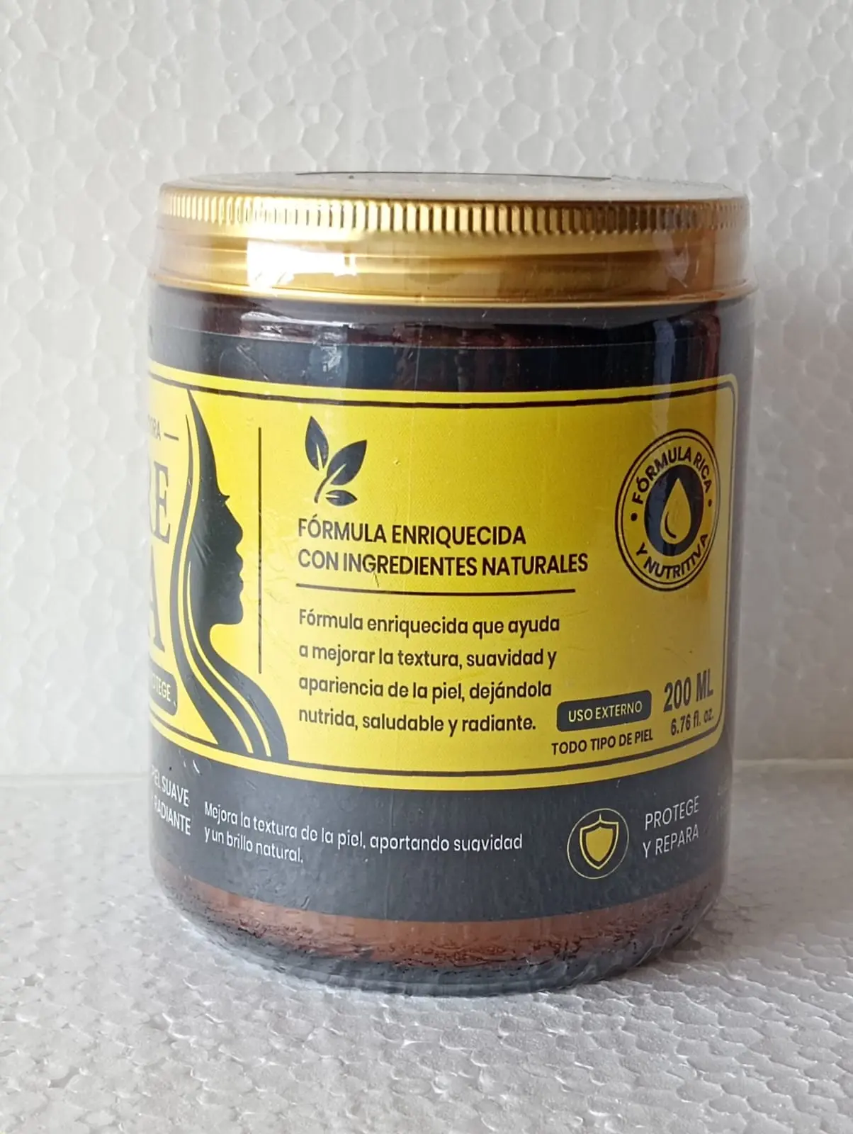 Tarro de crema facial Sempre Bela de 200 ml con tapa dorada y etiqueta amarilla con silueta femenina, sobre fondo blanco texturizado.