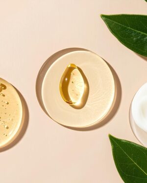 Cremas y aceites de cuidado personal junto a hojas verdes