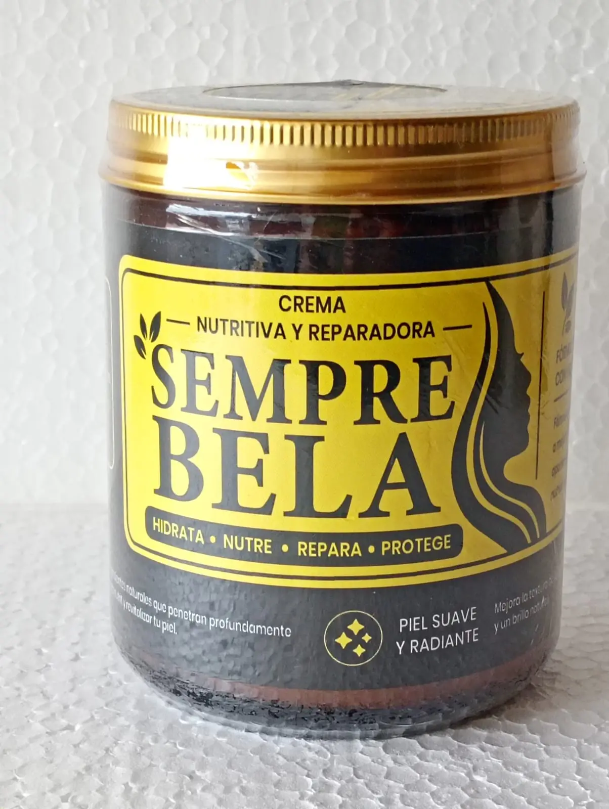 Frasco de crema nutritiva y reparadora Sempre Bela con tapa dorada y etiqueta amarilla y negra que destaca su función hidratante.