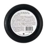 Parte inferior de tarro negro redondo con etiqueta blanca, que muestra instrucciones de uso, precauciones e ingredientes en inglés y español.