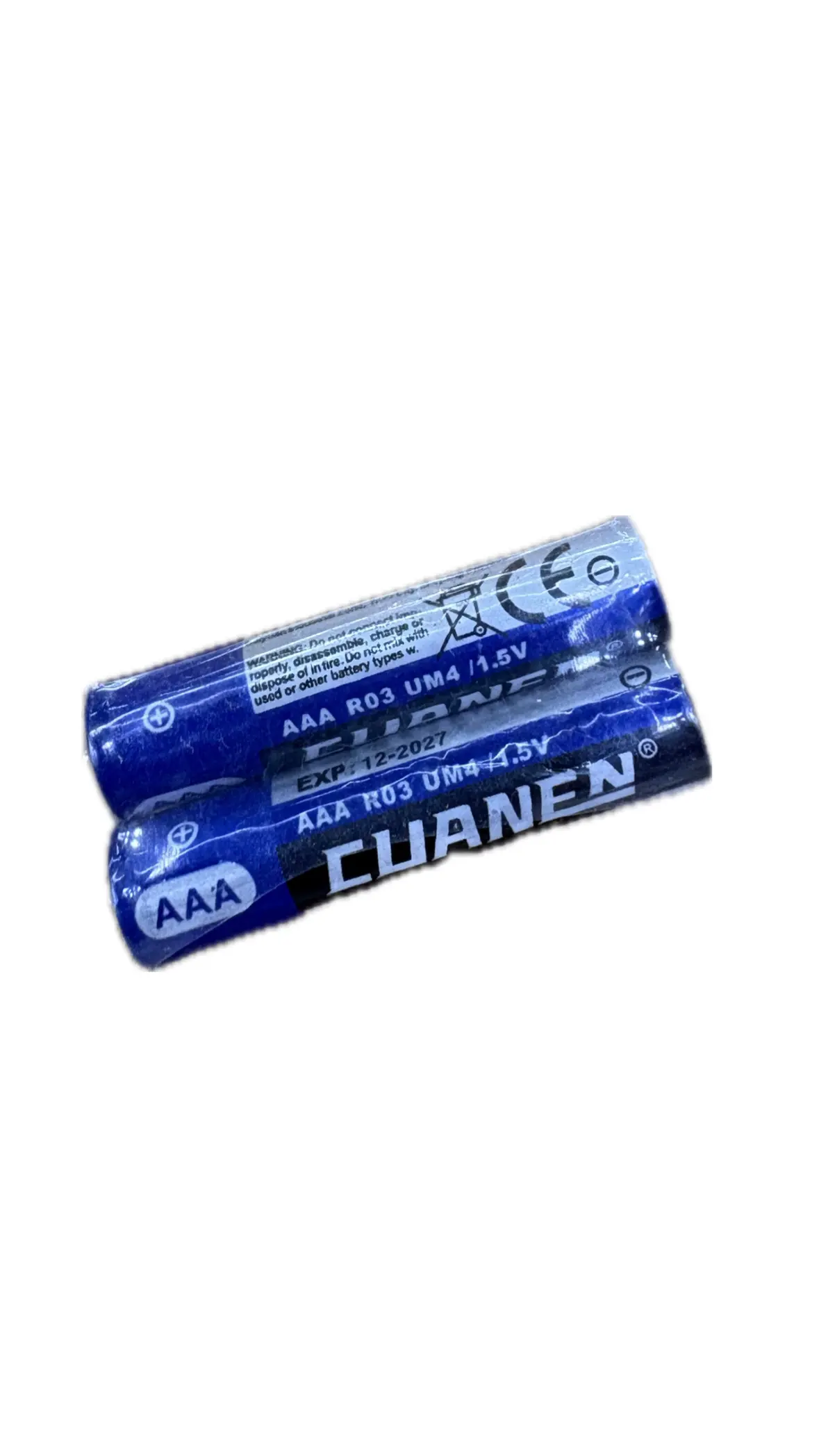 Par de pilas AAA azules marca Cuanen de 1.5V dispuestas en diagonal con indicadores de polaridad y fecha de vencimiento visibles.
