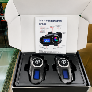 Caja abierta de intercomunicador para moto Bluetooth con manual, dos dispositivos negros con pantalla LCD y controles circulares.