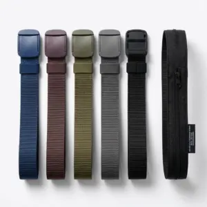 Set de cinco cinturones tácticos de lona con hebilla plástica plana en colores azul, vino tinto, verde, gris y negro, junto a un cinturón negro con bolsillo.
