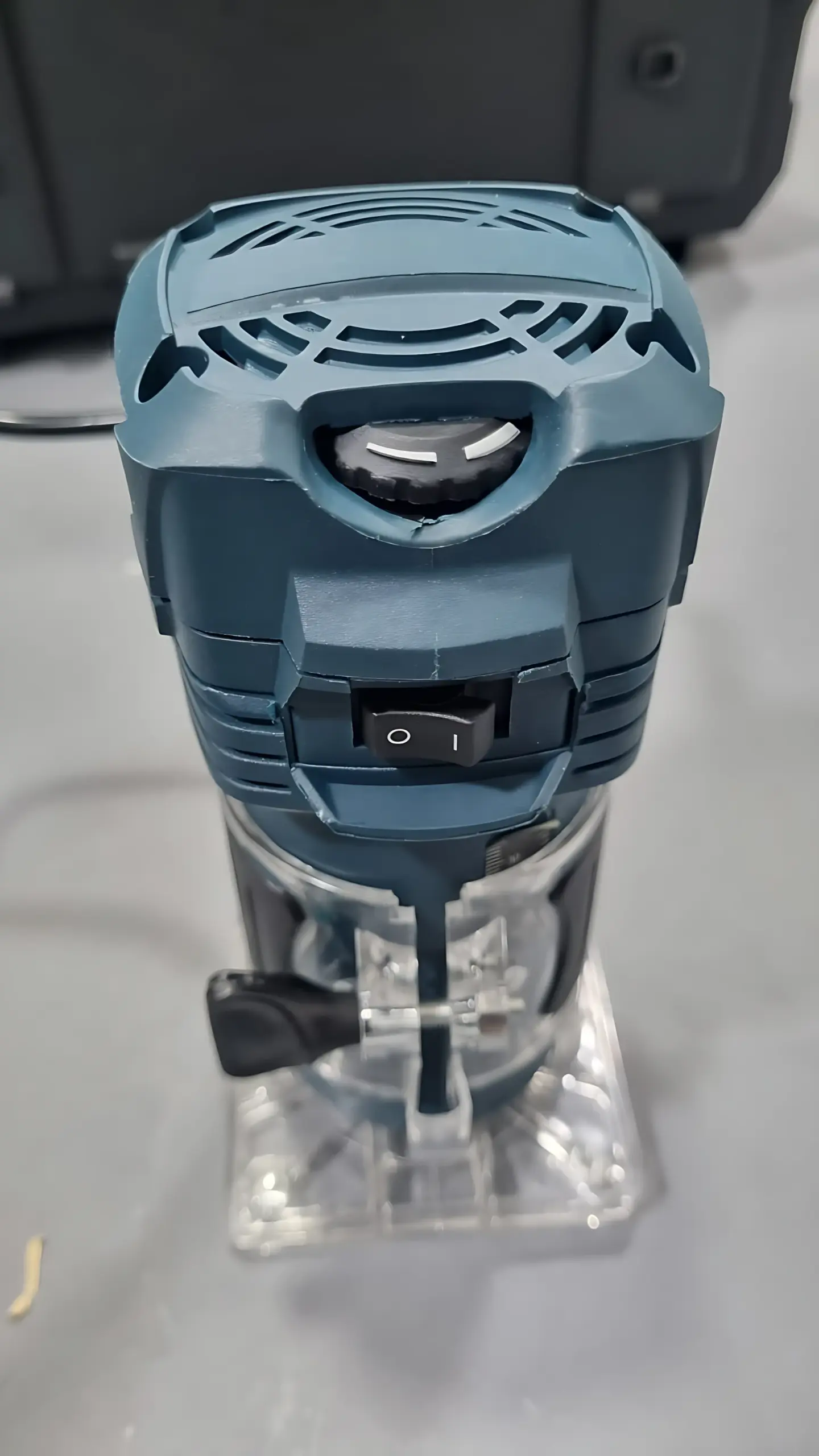 Rebordeadora eléctrica azul con base transparente, interruptor de encendido y perilla de ajuste superior, vista en ángulo frontal.
