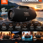 Parlante inalámbrico JBL Boombox 4 negro en superficie rocosa junto al agua, diseño portátil resistente al agua y polvo con asa integrada.