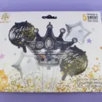 Set de 5 globos metalizados para fiesta: una corona negra central de 18", dos circulares con estampado "Feliz Día" y dos estrellas plateadas.