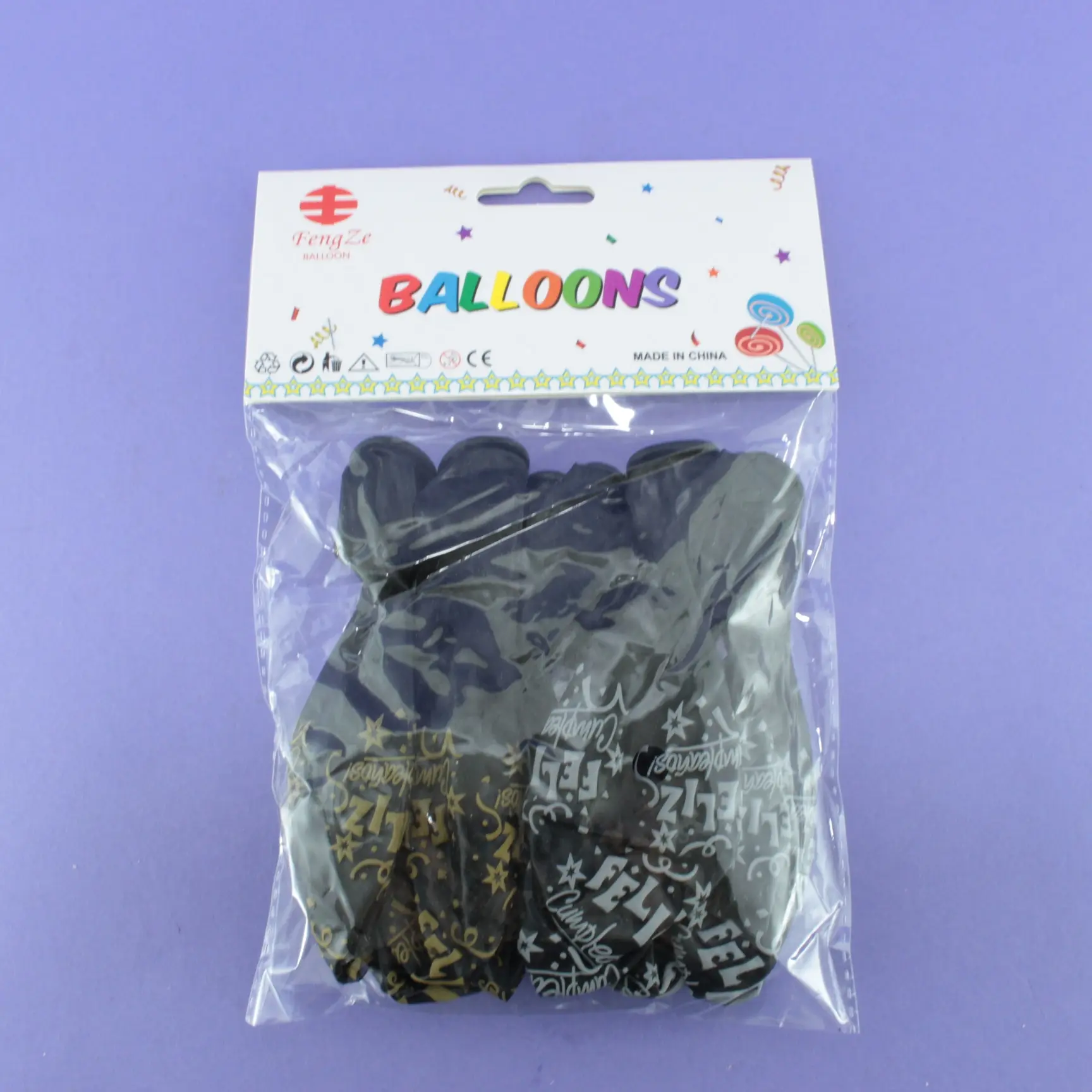 Paquete sellado con globos negros impresos con mensajes festivos en colores fluorescentes y dorados para luz ultravioleta.