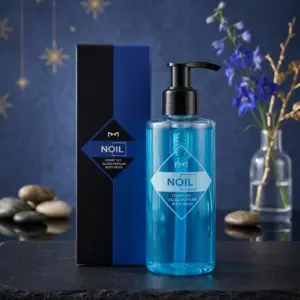 Jabón líquido corporal Noil Aquablue en envase transparente con dispensador, junto a su caja azul y negra sobre base de piedra, fondo estrellado y flores.