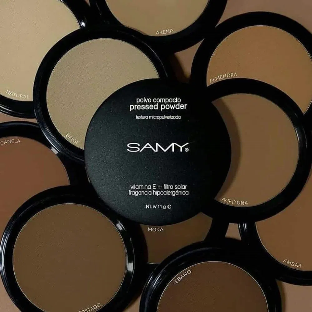 Variedad de tonos de polvo compacto Samy micropulverizado, de beige a marrón oscuro, con tapa negra que indica vitamina E y filtro solar.