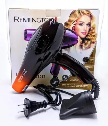 Secador profesional Remington negro con detalles naranja, incluye boquilla y cable con enchufe, frente a su caja de empaque.