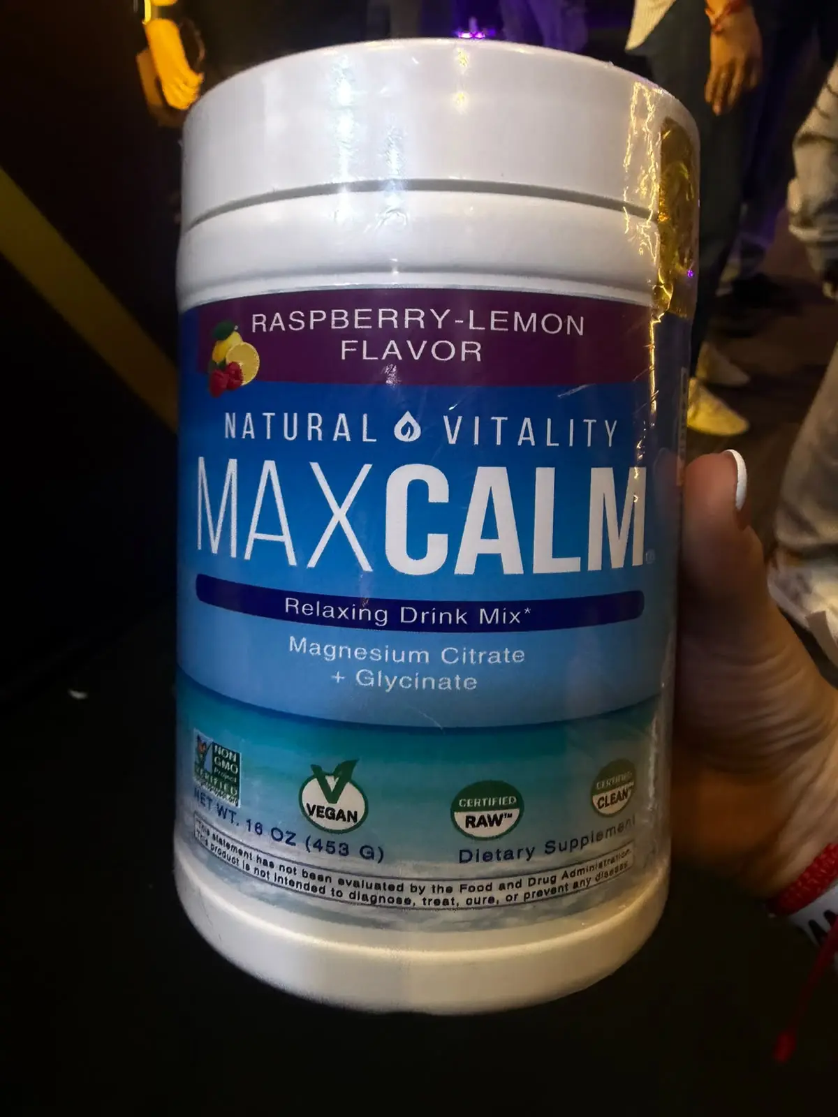 Envase blanco de Max Calm, suplemento de magnesio citrato y glicinato sabor frambuesa-limón, de 453 g con etiqueta azul y morada.