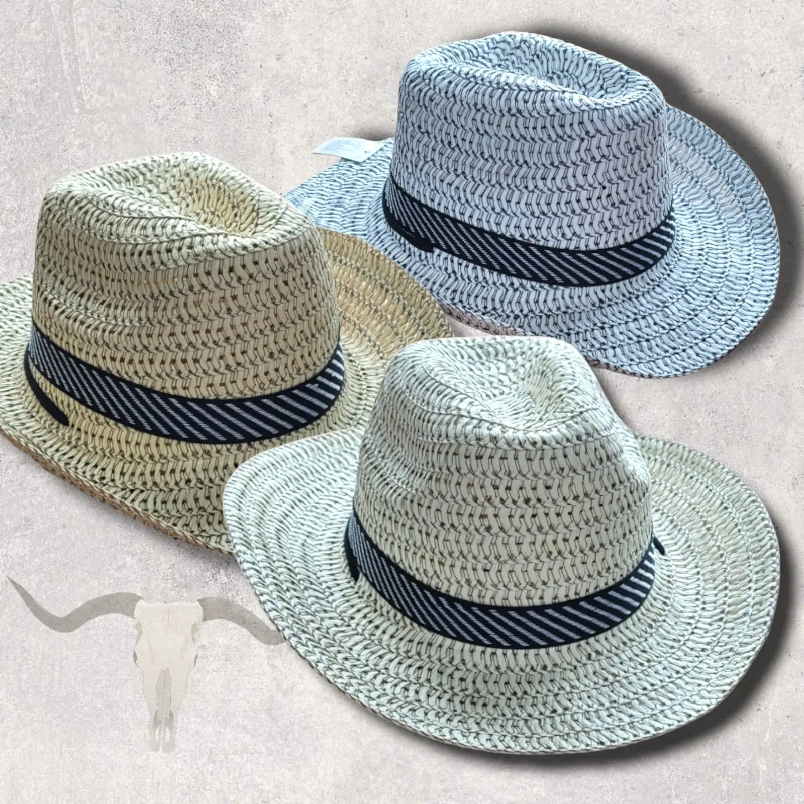 Tres sombreros de paja tejidos unisex en tonos beige, blanco y gris, con banda negra a rayas y diseño tipo Panamá y vaquero.