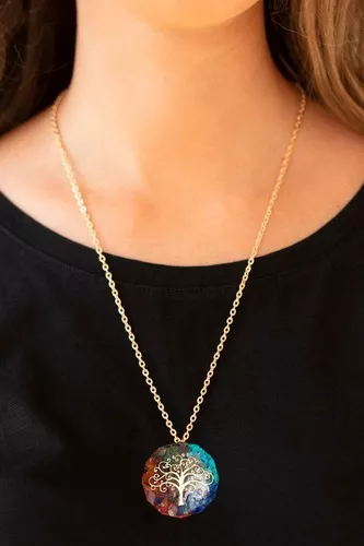 Collar largo dorado con colgante redondo de orgonita multicolor y diseño metálico del Árbol de la Vida sobre blusa negra.