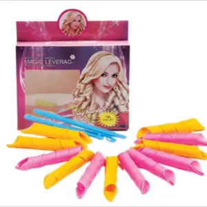 Rulos de tela en rosa y amarillo en semicírculo con dos herramientas azules frente a la caja de Roller Magic para crear rizos naturales.