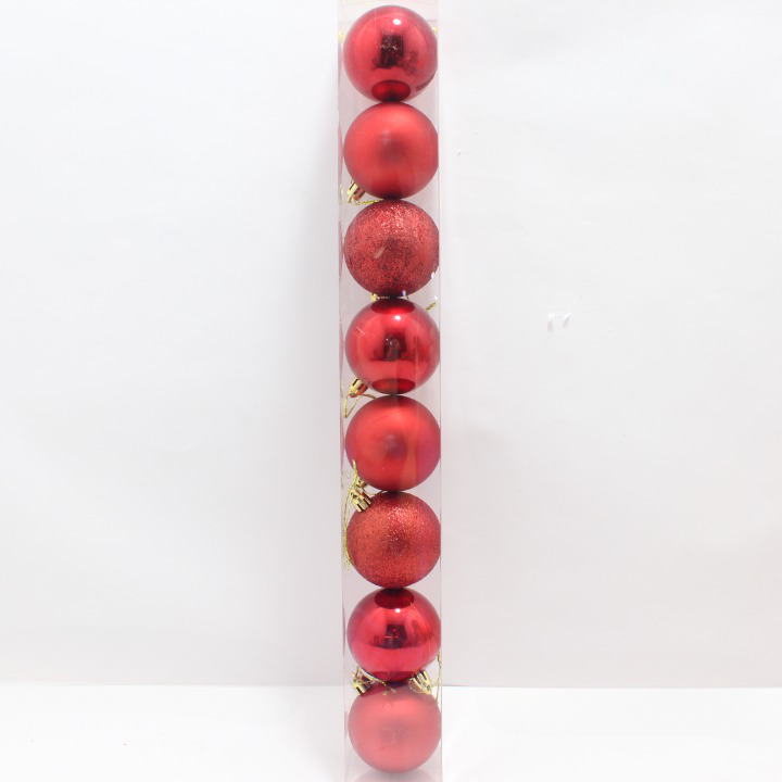 Tubo transparente vertical con ocho esferas navideñas rojas de seis centímetros, alternando acabados brillantes, mate y con escarcha.