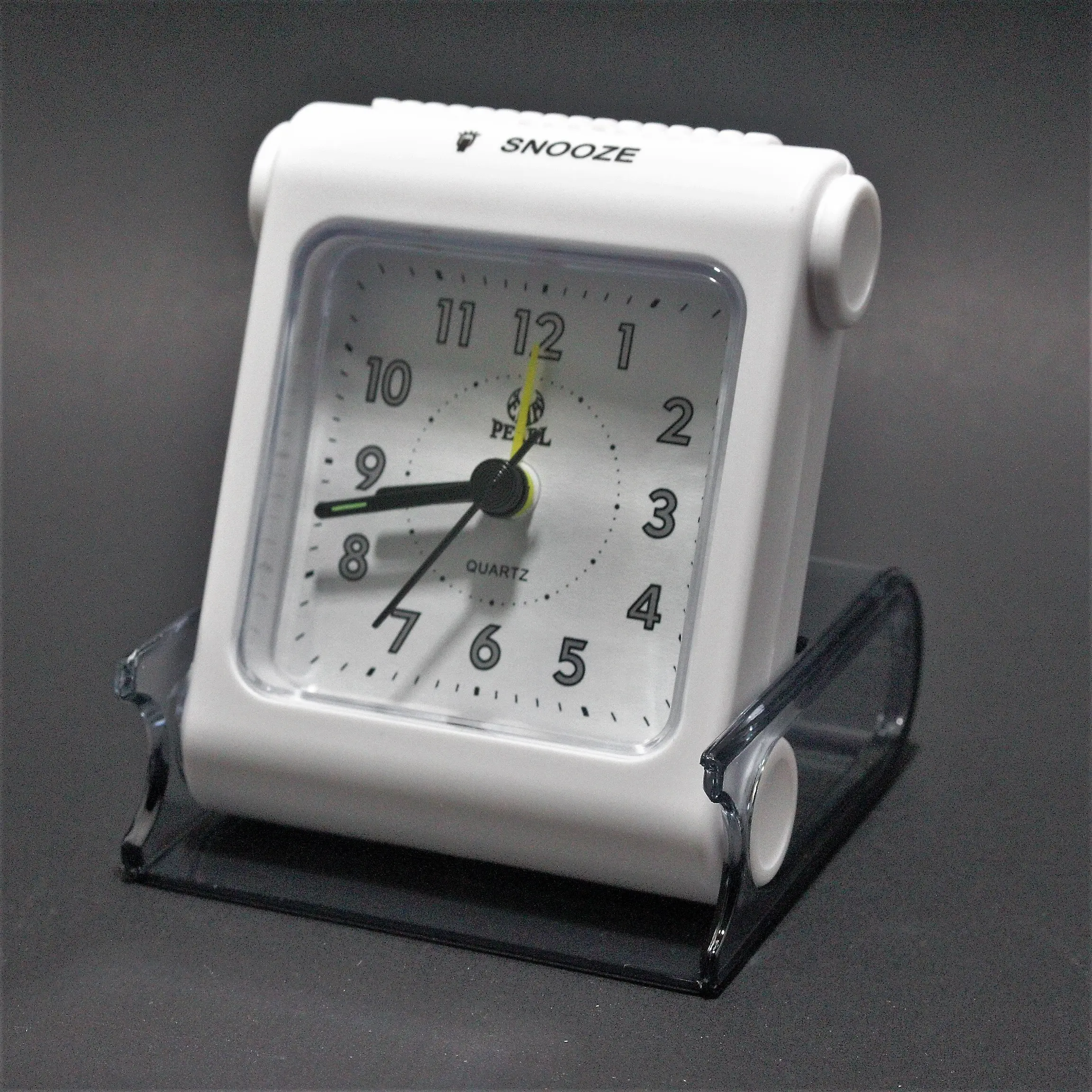 Reloj despertador de viaje blanco con esfera analógica y estuche protector transparente de acrílico.