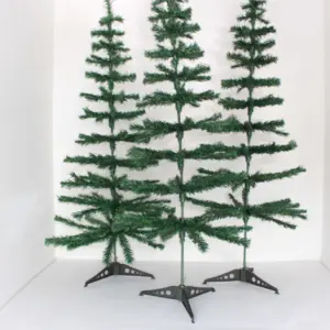 Tres árboles de Navidad artificiales verdes y armables de 120 cm con base plástica en esquina blanca.