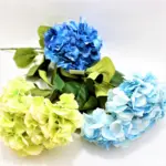 Set de tres ramos de flores hortensias artificiales en colores azul oscuro, azul claro y verde claro, con tallos y hojas verdes para decoración.