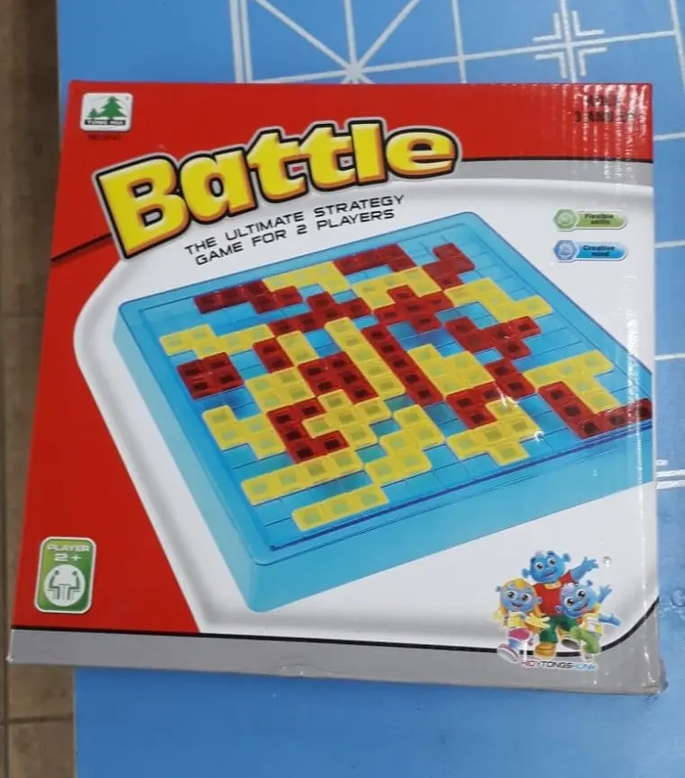 Caja roja de juego de mesa de estrategia Battle para dos jugadores, con tablero azul y piezas geométricas amarillas y rojas encajadas.