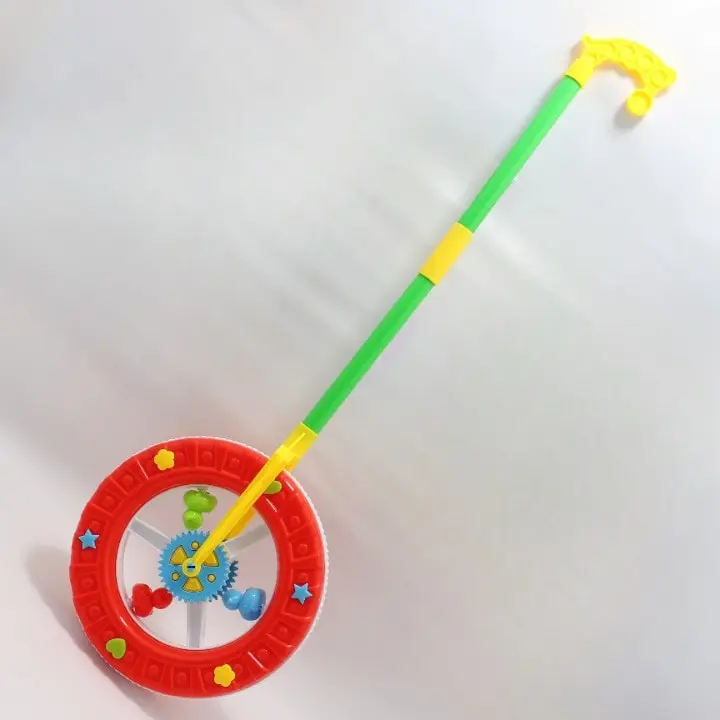Juguete didáctico de empuje en forma de rueda roja con engranajes multicolores y mango verde y amarillo para primeros pasos.