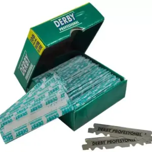 Caja verde abierta de hojas de afeitar Derby Professional con varias cuchillas envueltas y dos sueltas al frente.
