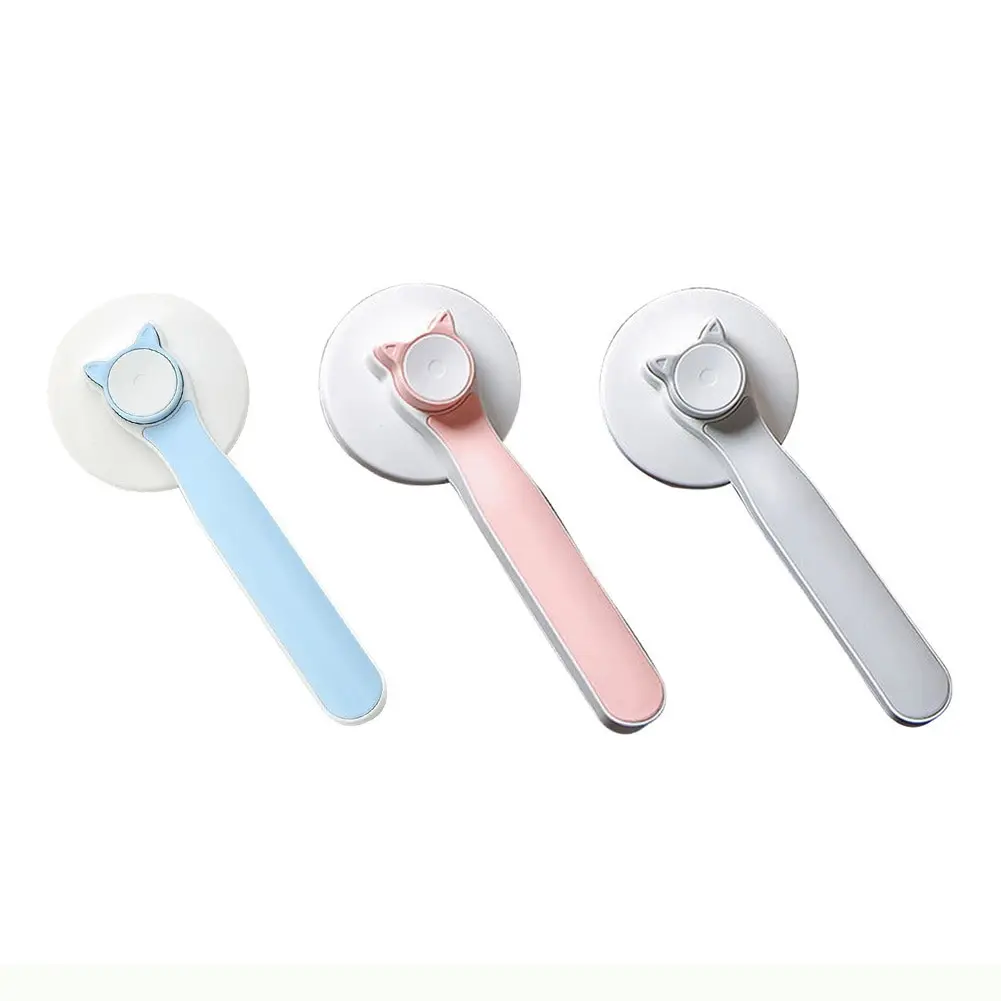 Set de tres cepillos para mascotas con diseño de orejas de gato, en colores azul, rosado y gris, con mango ergonómico y cabezal redondo.