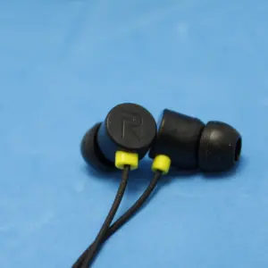Auriculares intraauditivos Realme S-20 negros con detalles amarillos, almohadillas de silicona y cable sobre fondo azul.