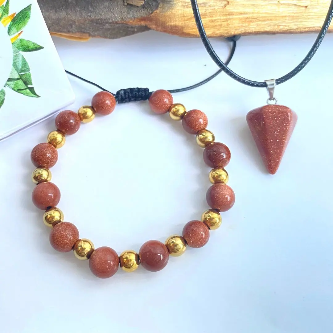Set de pulsera de cuentas rojizas y doradas con cordón negro y péndulo triangular de piedra natural con destellos brillantes.