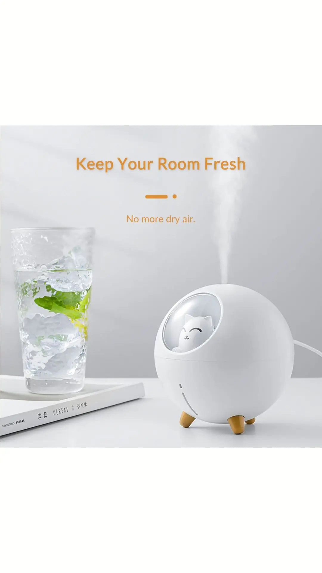 Humidificador ultrasónico portátil blanco redondo con diseño de gato y luz nocturna, sobre una mesa junto a un vaso con hielo y menta.