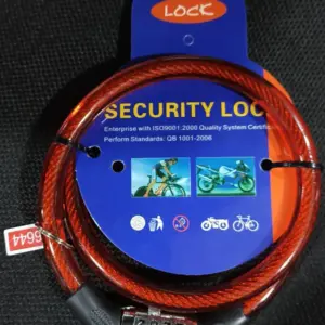 Guaya de seguridad color rojo con combinación numérica, cable de acero trenzado y empaque circular azul de cartón.