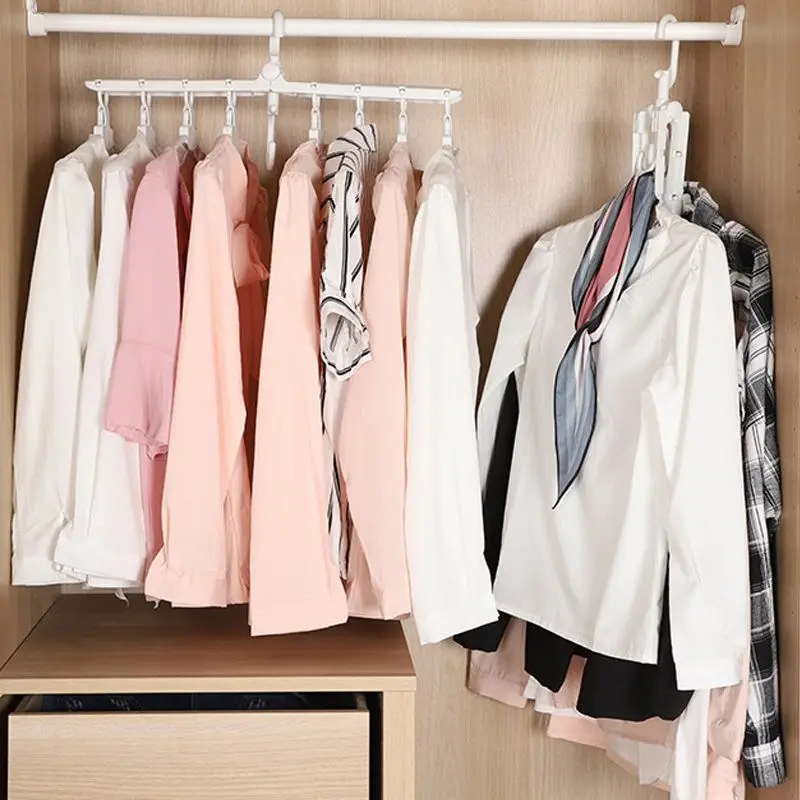 Set de dos perchas organizadoras blancas y plegables con diseño 8 en 1 colgadas en barra de madera, ahorrando espacio en armario.