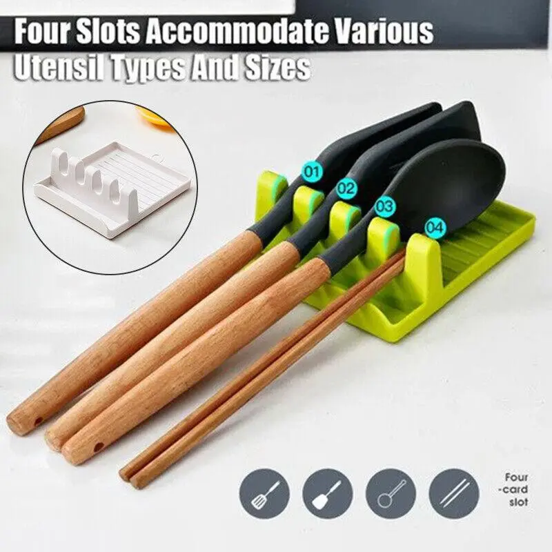 Soporte verde de cocina con cuatro ranuras para organizar utensilios, incluyendo espátulas y palillos, sobre una superficie blanca con diseño antideslizante.