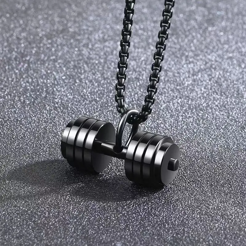 Collar de acero de titanio negro en forma de mancuerna clásica con placas concéntricas y cadena cuadrada colgando sobre superficie texturizada.