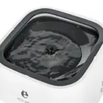Bebedero anti-derrames para perros color blanco con borde gris oscuro, cuenco cuadrado y disco flotante central en agua.