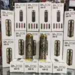 Dos máquinas para barba doradas con grabados orientales sobre una pila de cajas blancas HW-T8.