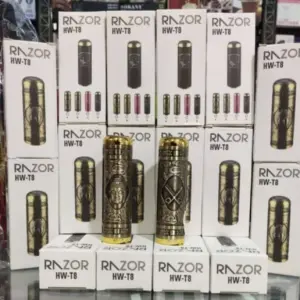 Dos máquinas para barba doradas con grabados orientales sobre una pila de cajas blancas HW-T8.