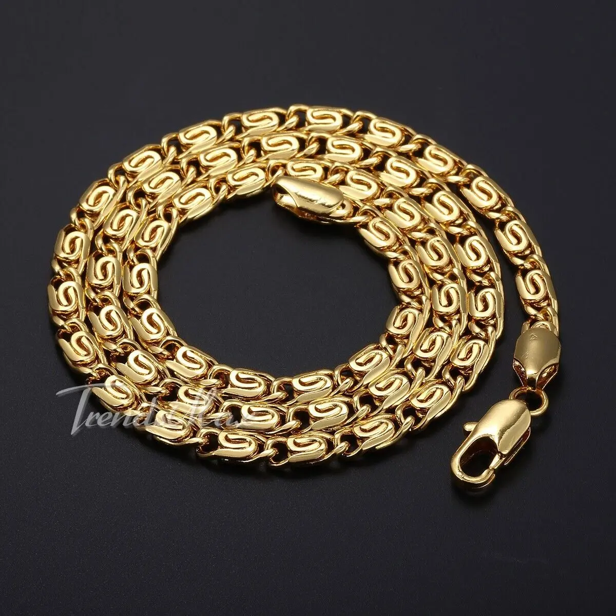 Set de dos collares de eslabón caracol dorado en acero inoxidable, dispuestos en espiral sobre fondo oscuro con broches de langosta.