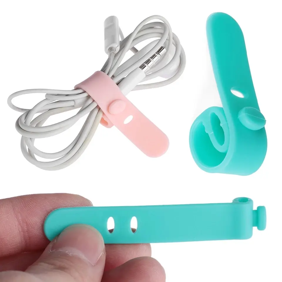 Set de organizadores de cables de silicona en colores rosado y turquesa, mostrando un broche sujetando audífonos y otro suelto.