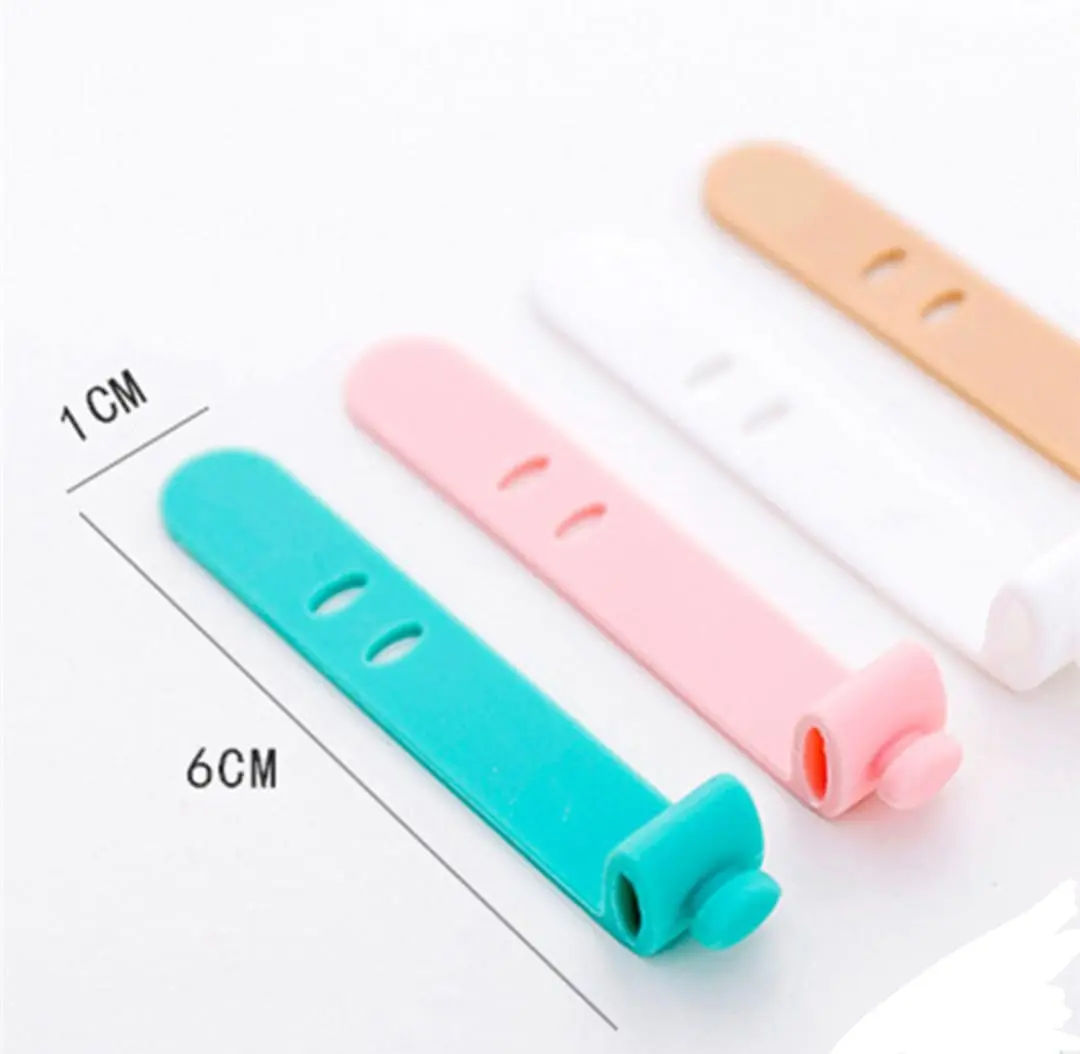 Broches organizadores de cables de silicona en colores turquesa, rosa, blanco y durazno, con medidas de 6 cm de largo por 1 cm de ancho.
