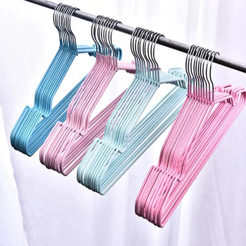 Set de ganchos metálicos con recubrimiento antideslizante en colores azul, rosado y celeste, colgados de un tubo metálico.
